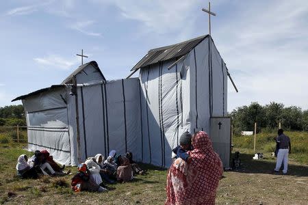 Christian migrants from Eritrea and Ethiopia attend the Sunday mass at the makeshift church in "The New Jungle" near Calais, France, August 2, 2015. REUTERS/Pascal Rossignol