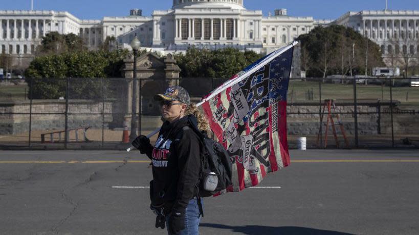Una simpatizante de Trump con una bandera frente al Capitolio.