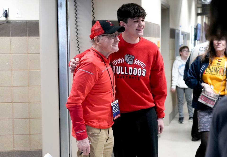 Iowa wrestling legend Dan Gable, left, signs autographs for fans during the Iowa high school boys state wrestling tournament on Thursday, Feb. 15, 2024, at Wells Fargo Arena in Des Moines, Iowa.