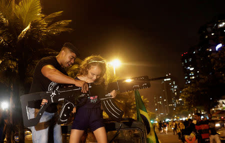 FILE PHOTO: Supporters of Brazil's President Jair Bolsonaro, hold a cardboard gun, after Bolsonaro wins the presidential race, in Rio de Janeiro, Brazil October 28, 2018. REUTERS/Ricardo Moraes/File photo