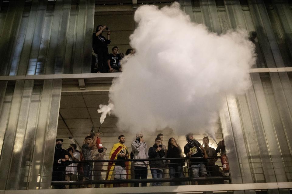 A protester uses a fire extinguisher against police, not pictured, during a demonstration at El Prat airport, outskirts of Barcelona, Spain, Monday, Oct. 14, 2019. Spain's Supreme Court on Monday sentenced 12 prominent former Catalan politicians and activists to lengthly prison terms for their roles in a 2017 bid to gain Catalonia's independence, sparking protests across the wealthy Spanish region. (AP Photo/Bernat Armangue)