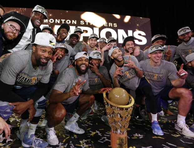 The Edmonton Stingers celebrate with the trophy after cruising to their second consecutive CEBL title with a 101-65 win over the Niagara River Lions on Sunday. (Ian Kucerak/CEBL - image credit)