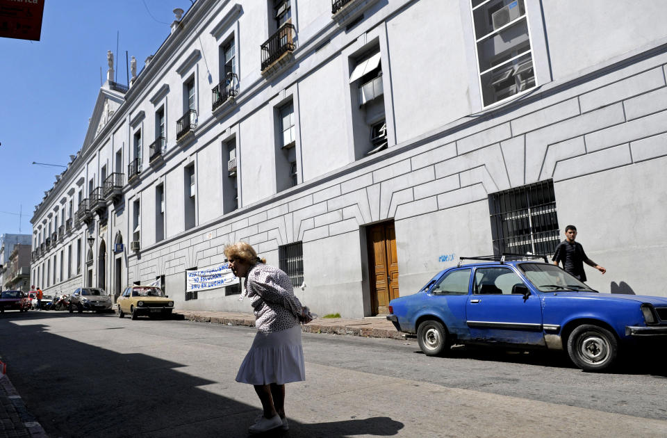 A woman walks by Maciel public hospital in Montevideo, Uruguay, Sunday March 18, 2012. Uruguayan police say an investigation into dozens of possibly induced deaths at two hospitals, including Maciel, has led to the detention of at least two people. Police inspector Jose Luis Roldan said Sunday that officials suspect that hospital workers brought a sort of poison from Brazil and gave it to patients who were in critical condition. (AP Photo/Matilde Campodonico)