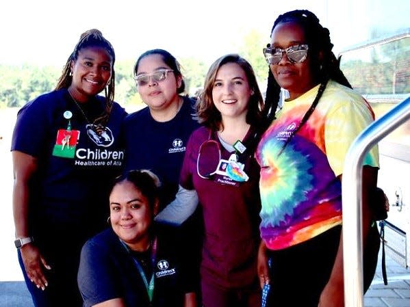 The Care Mobile staff helping kids at the visit were, from left, Shavail Pierce, Tania Romero, Caroline Muller, Katrina Robinson, and on front, Veronica Ciprian