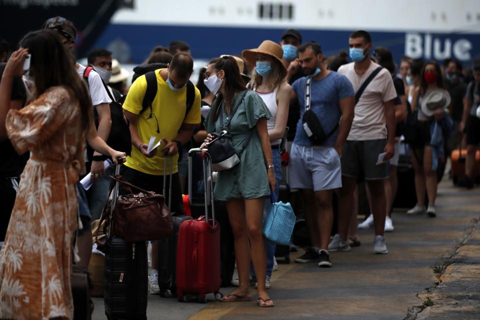 People wearing face masks to prevent the spread of coronavirus wait to board a ferry in the port of Piraeus, near Athens, on Friday, Aug. 7, 2020. Young people "are not invincible", the World Health Organization (WHO) officials said a week ago while the last days Greece recorded increase in COVID-19 infections and the authorities has warned against complacency in maintaining protective measures. (AP Photo/Thanassis Stavrakis)