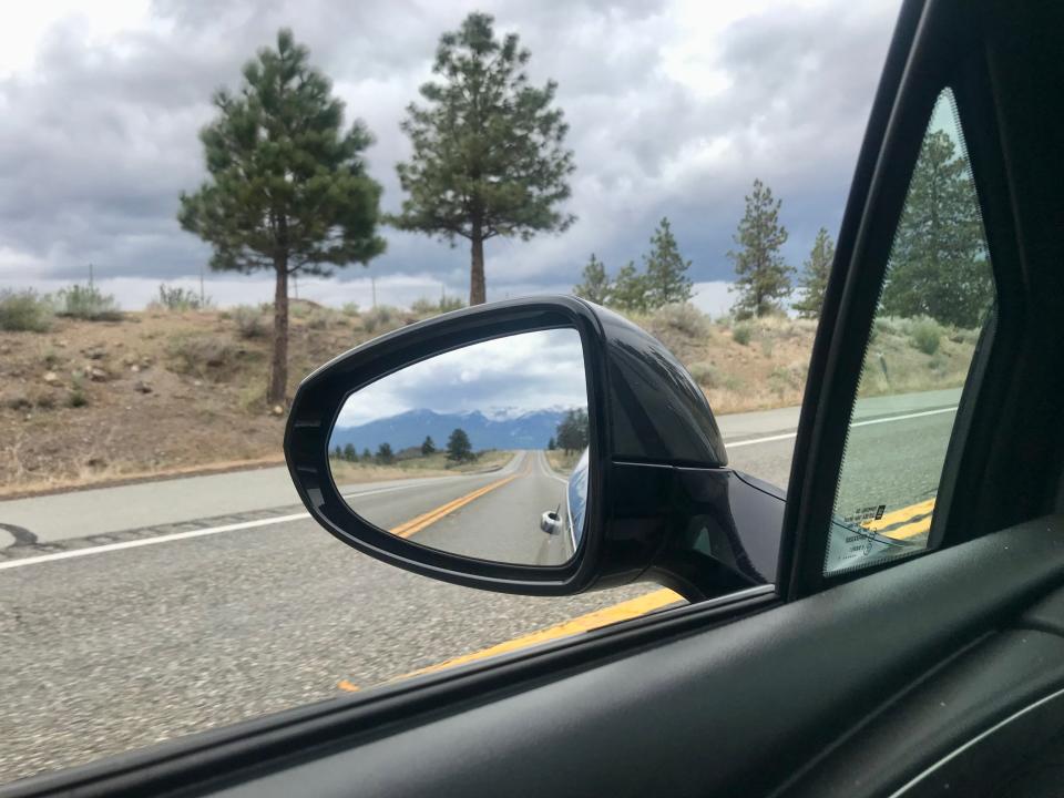 mountains in the rearview mirror of a car