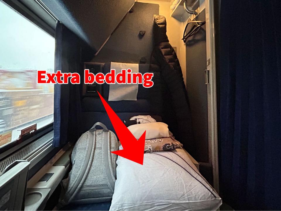 A photo of an Amtrak roomette with an arrow pointing to extra pillows available in the room.