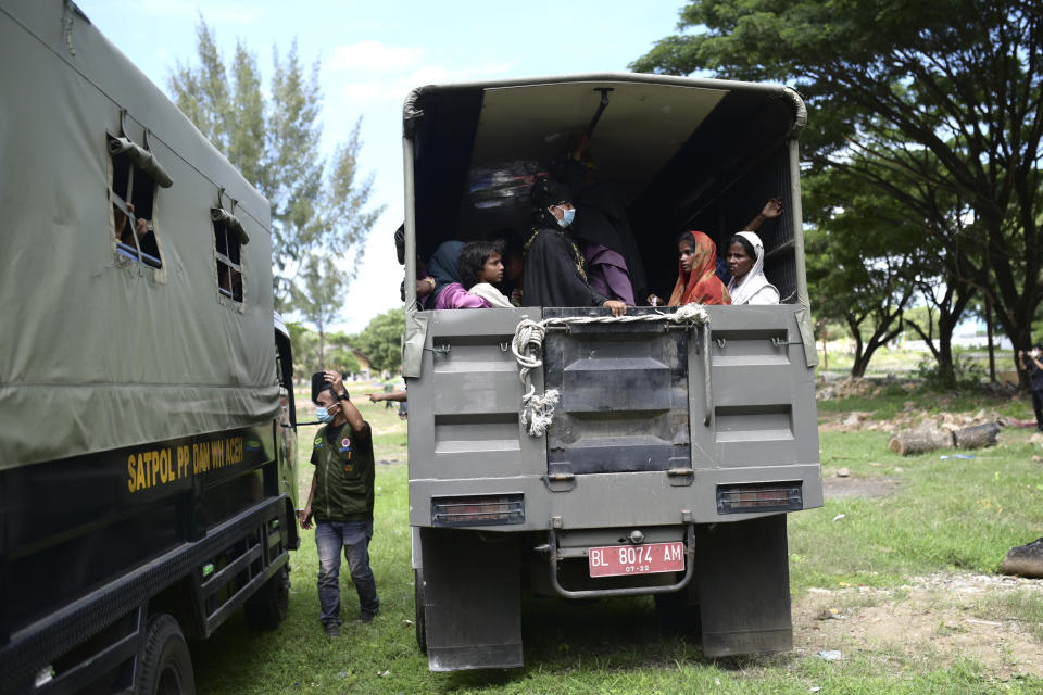 Rohingya women and children sit on the back of a truck as they are being transferred to a temporary shelter, in Banda Aceh, Aceh province, Indonesia, Monday, Dec. 11, 2023. Two boats carrying hundreds of Rohingya Muslims, including emaciated women and children, arrived on Sunday at Indonesia's northernmost province of Aceh where they faced rejection from local communities who are protesting against the increasing numbers of refugees that have entered the region over the past few weeks. (AP Photo/Reza Saifullah)