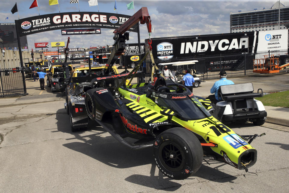 The car of driver Ed Jones is towed to the garage after a multiple-car wreck at the beginning of an IndyCar Series auto race at Texas Motor Speedway on Sunday, May 2, 2021, in Fort Worth, Texas. (AP Photo/Richard W. Rodriguez)