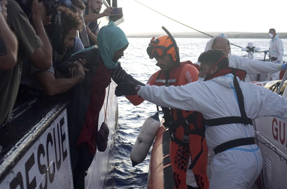 Migrants are evacuated by Italian Coast guards from the Open Arms Spanish humanitarian boat off the coast of the Sicilian island of Lampedusa, southern Italy, Thursday, Aug. 15, 2019. A Spanish aid boat with 147 rescued migrants aboard is anchored off a southern Italian island as Italy's ministers spar over their fate. (AP Photo/Francisco Gentico)