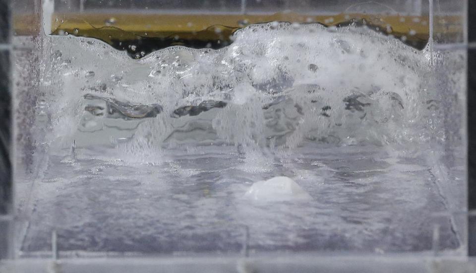 In this photograph taken, Friday, Sept. 20, 2013, in Middlesex, N.J., a wipe, center, is put through a machine that tests the strength of the wipe in active water. At that point, the wipe had been in the moving water for 15:51 hours and the wipe was still holding its shape. Increasingly popular bathroom wipes _ thick, premoistened towelettes that are advertised as flushable _ are creating clogs and backups in sewer systems around the nation. The problem has gotten so bad in this upstate New York town that frustrated sewer officials traced the wipes back to specific neighborhoods, and even knocked on doors to break the embarrassing news to residents that they are the source of a costly, unmentionable mess. An industry trade group this month revised its guidelines on which wipes can be flushed, and has come out with a universal stick-figure, do-not-flush symbol to put on packaging. (AP Photo/Julio Cortez)