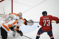 Philadelphia Flyers goaltender Alex Lyon (34) and defenseman Travis Sanheim (6) work for the puck against Washington Capitals left wing Conor Sheary (73) during the first period of an NHL hockey game Saturday, May 8, 2021, in Washington. (AP Photo/Nick Wass)