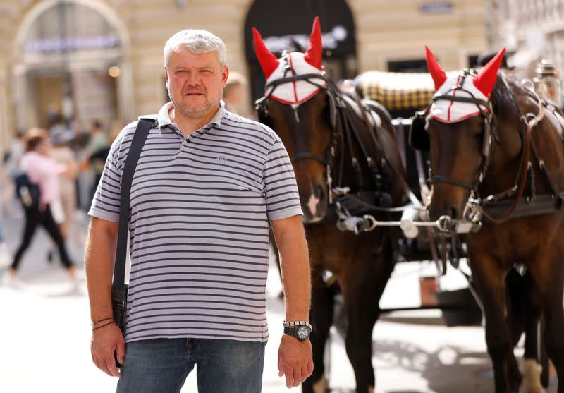 Ukrainian business man Oleh Maiboroda walks past a fiaker horse carriage in Vienna