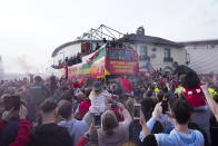 Members of the Wrexham FC soccer team ride on an open top bus as they celebrate promotion to the Football League in Wrexham, Wales, Tuesday, May 2, 2023. (AP Photo/Jon Super)