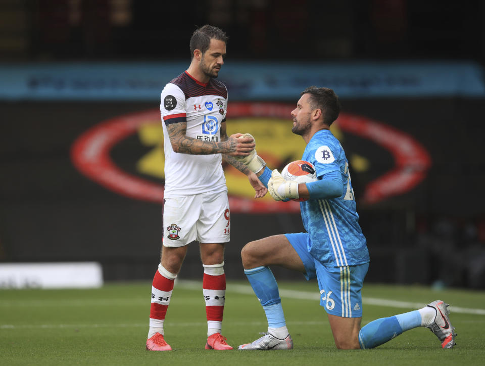 Southampton's Danny Ings, left helps Watford's goalkeeper Ben Foster to his feet after the end of the English Premier League soccer match between Watford and Southampton at the Vicarage Road Stadium in Watford, England, Sunday, June 28, 2020. Southampton won the game 3-1, with Ings scoring twice. (Adam Davy/Pool via AP)