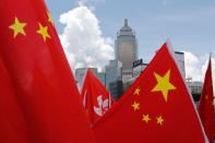 Buildings are seen above Hong Kong and Chinese flags, as pro-China supporters celebration after China's parliament passes national security law for Hong Kong, in Hong Kong