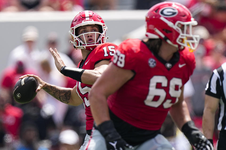 Georgia quarterback Carson Beck (15) throws a pass behind the blocking of offensive lineman Tate Ratledge (69) in the first half of an NCAA college football game against Ball State Saturday, Sept. 9, 2023, in Athens, Ga. (AP Photo/John Bazemore)