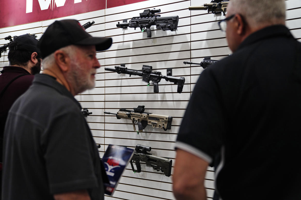 Visitors look at rifles at the annual NRA convention Friday.  (Allison Dinner for NBC News)