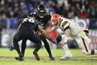 Cleveland Browns quarterback Baker Mayfield, right, fumbles the ball as Baltimore Ravens safety Geno Stone (26) and safety Chuck Clark (36) try to recover the fumble during the first half of an NFL football game, Sunday, Nov. 28, 2021, in Baltimore. The Ravens recovered the loose ball. (AP Photo/Gail Burton)