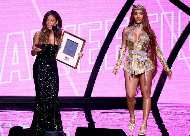 <p>Emma McIntyre/Getty</p> Trinidad Valentin presents the Game Changer Award to honoree Saweetie onstage during Billboard Women in Music 2022 on March 02, 2022 in Inglewood, California.