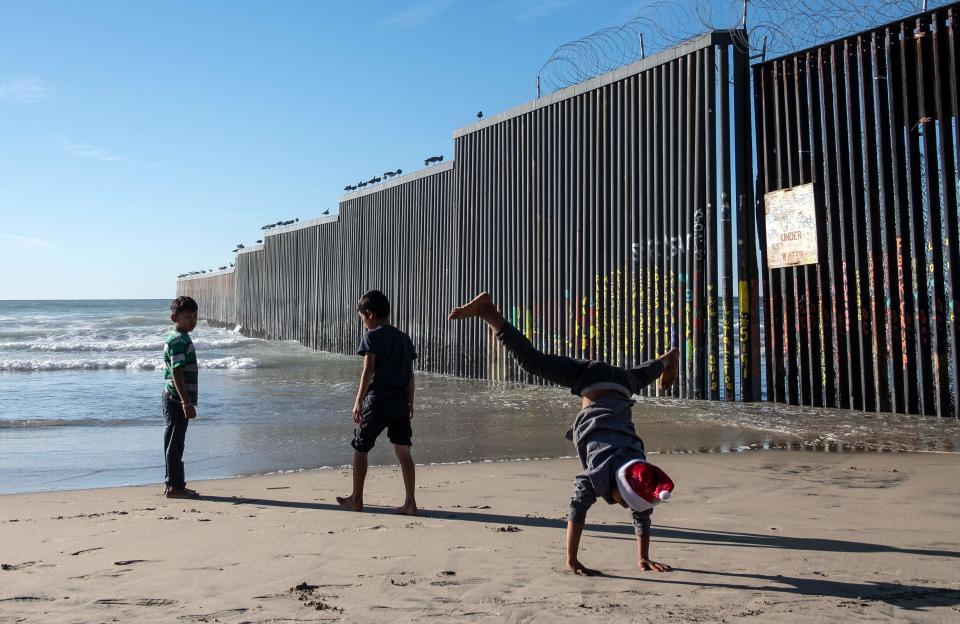 Children traveling with the Central American migrants that hope to reach the United States, play at the beach next to the US-Mexico border fence in Playas de Tijuana, Baja California State, Mexico, on Dec. 29, 2018.  El Salvador insisted Saturday that it is taking steps to curb illegal migration to the United States, fending off criticism from President Donald Trump, a day after he threatened to cut off aid to nations in Central America's Northern Triangle, Honduras, Guatemala and El Salvador.