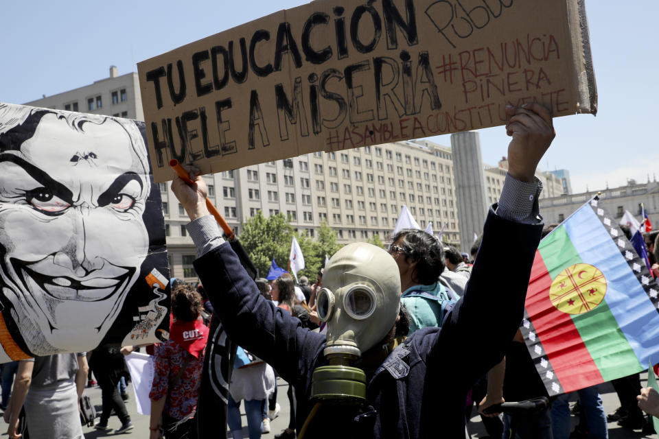 Anti-government demonstrators gather outside La Moneda presidential palace in Santiago, Chile, Wednesday, Oct. 30, 2019. Chilean President Sebastián Pinera cancelled two major international summits after nearly two weeks of nationwide protests over economic inequality that have left at least 20 dead and damaged businesses and infrastructure around the country.(AP Photo/Rodrigo Abd)