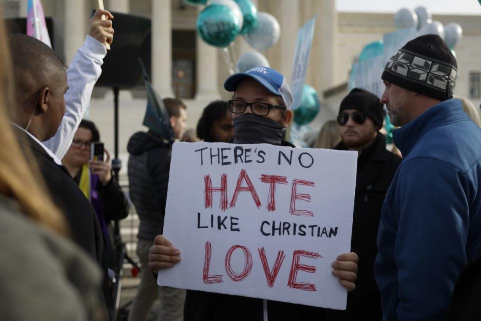 A photo of Lorie Smith and Protesters in front of SCOTUS, Supreme Court of The United States