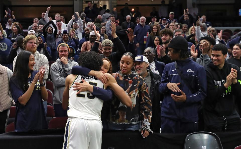 Akron Zips forward Enrique Freeman (25) hugs his family after beating the Ohio Bobcats in an NCAA college basketball game in the semifinals of the Mid-American Conference Tournament at Rocket Mortgage FieldHouse, Friday, March 15, 2024, in Cleveland, Ohio.