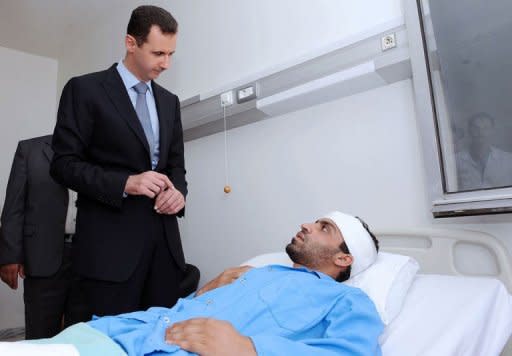 A handout picture released by the Syrian Arab News Agency (SANA) shows Syrian President Bashar al-Assad visiting a wounded soldier at a hospital in Damascus. Syrian tanks "indiscriminately" shelled a residential area on the outskirts of Hama late on Monday, an activist in the flashpoint protest city told AFP by telephone