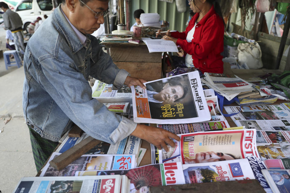 A man looks through newspapers with front pages leading with Myanmar leader Aung San Suu Kyi at the International Court of Justice hearing, near a roadside journal shop Thursday, Dec. 12, 2019, in Yangon, Myanmar. Suu Kyi testified to the court that the exodus of hundreds of thousands of Rohingya Muslims to neighboring Bangladesh was the unfortunate result of a battle with insurgents. She denied that the army had killed civilians, raped women and torched houses. (AP Photo/Thein Zaw)