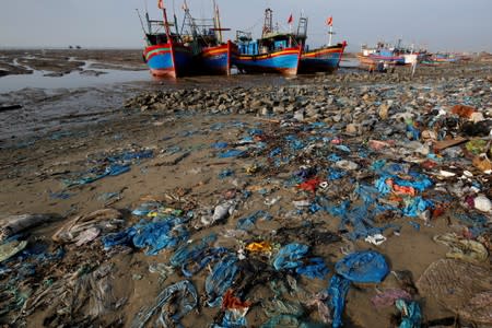 FILE PHOTO: Fishermen boats are seen at a beach covered with plastic waste in Thanh Hoa province