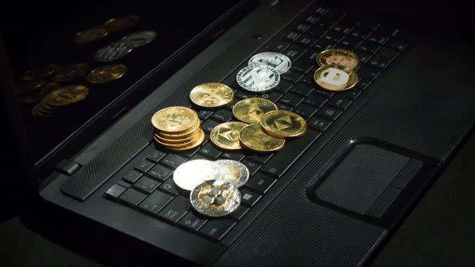 Laptop with cryptocurrencies over dark floor.