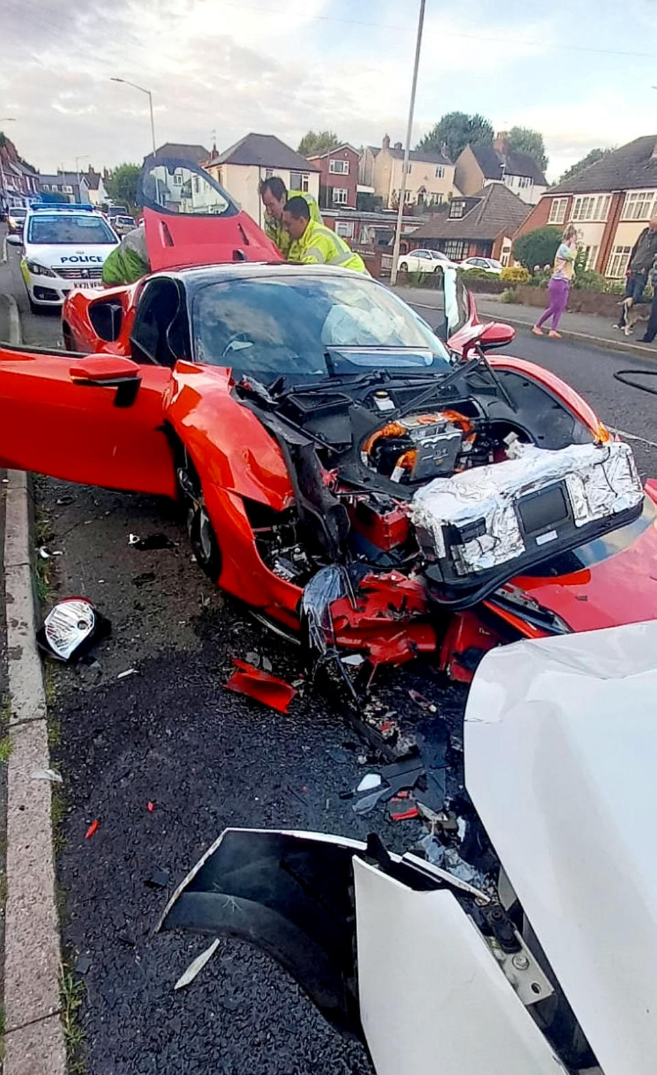 Severe damage caused to a £500,000 Ferrari SF90 involved in a head-on crash in Halesowen, West Midlands.  See SWNS story SWMDferrari. The hypercar, dubbed the 'quickest car of the decade', crashed on Hagley Road last night, Wednesday, May 25.  Firefighters from Haden Cross Fire Station attended the scene and shared photos of the car on social media. The pictures show the extent of the damage including bits of the car strewn over the road. 