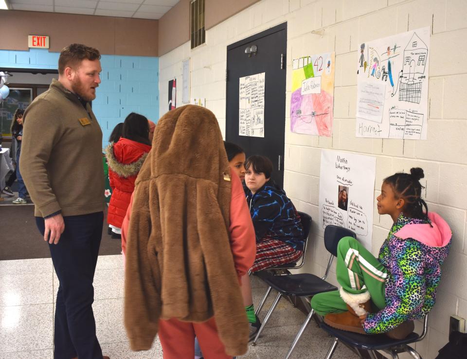 Cody Waters, left, chief executive officer of the Boys & Girls Club of Lenawee, chats with students and club members Feb. 1 during the club's inaugural Black History Month biography fair at the clubhouse in Adrian.