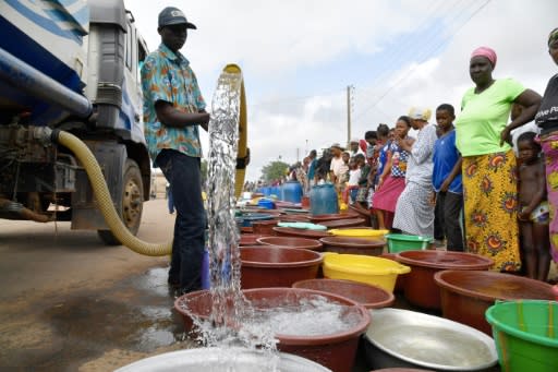 A supplier distributes water from a tanker truck to residents of Bouake at the start of July 2018