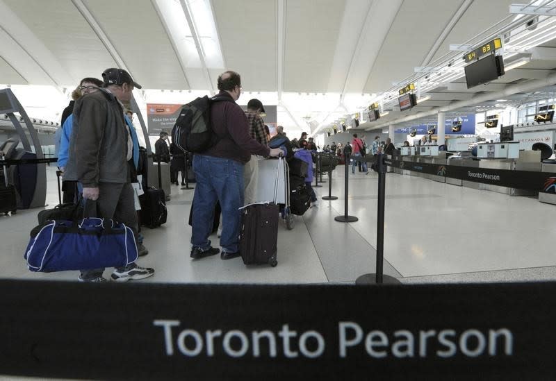 Air Canada passengers line-up at the baggage check-in counter at Pearson International Airport in Toronto April 13, 2012. REUTERS/Mike Cassese