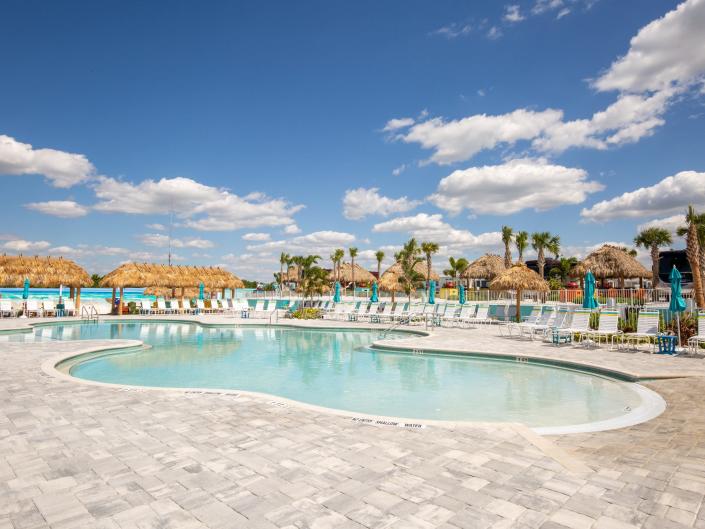 A pool with lounge chairs surrounding it.