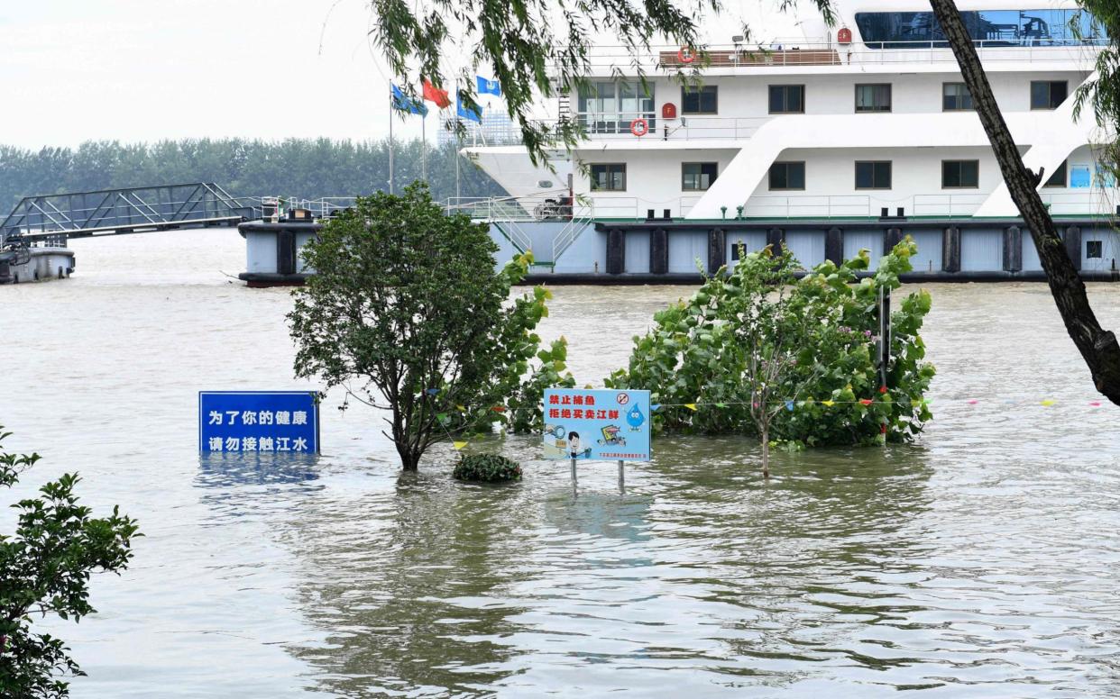 Signs are submerged in floodwaters on the bank of the Yangtze River in Nanjing in China's eastern Jiangsu province - AFP