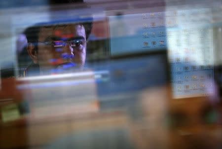 A broker monitors share prices while trading at a brokerage firm in Mumbai August 22, 2013. REUTERS/Danish Siddiqui/Files