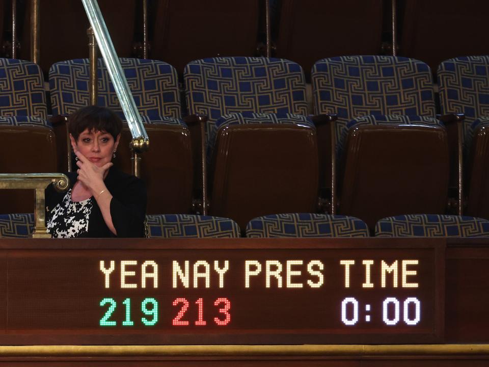 Kevin McCarthy's wife sits by a sign in the House chamber indicating vote numbers