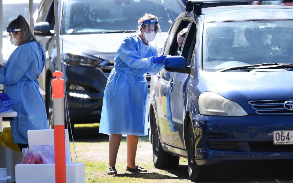 Photo by DAN PELED/EPA-EFE/Shutterstock (12240365d) Health workers swab members of the public at a pop-up COVID-19 testing station at Indooroopilly State High School in Brisbane, Queensland, Australia, 31 July 2021. Queensland has recorded six new community cases of the Delta coronavirus strain, reportedly originating from a student at the school, prompting a strict partial lockdown. COVID-19 pandemic in Queensland, Brisbane, Australia  - Shutterstock