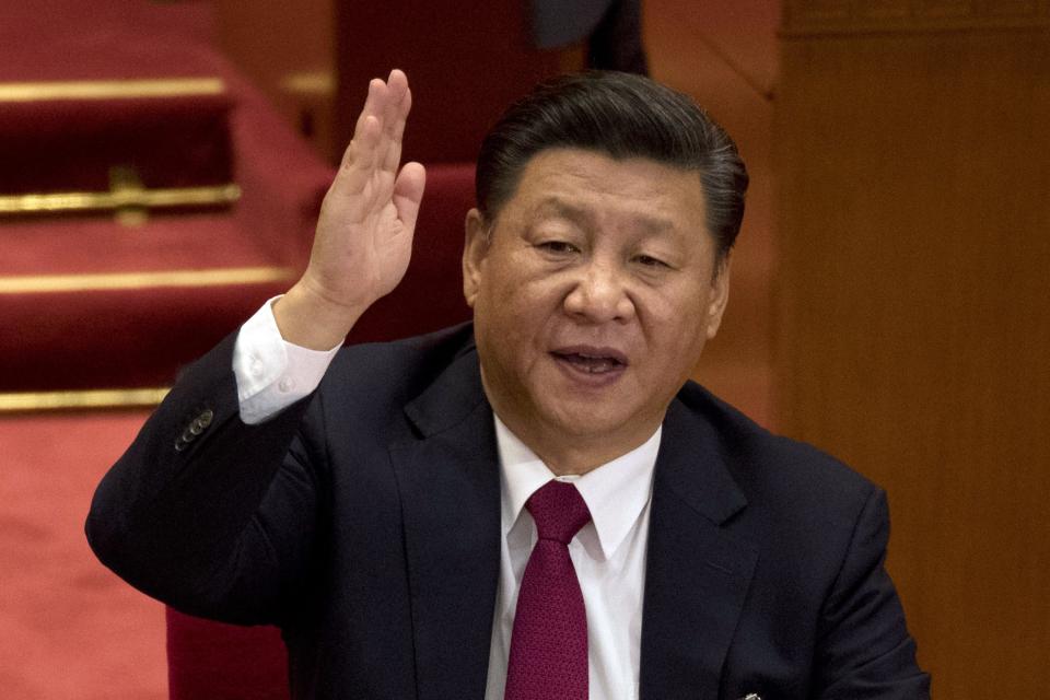 In this Oct. 24, 2017, file photo, Chinese President Xi Jinping raises his hand to show approval of a work report during the closing ceremony for the 19th Party Congress at the Great Hall of the People in Beijing, China.