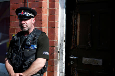 A police officer stand outside a property in Moss Side, following overnight raids in Manchester, Britain May 25, 2017. REUTERS/Andrew Yates