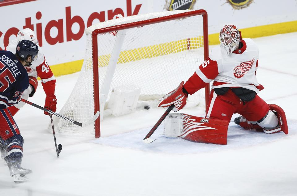 Winnipeg Jets' Mark Scheifele (55) scores aganst Detroit Red Wings goaltender Magnus Hellberg (45) during first-period NHL hockey game action in Winnipeg, Manitoba, Friday, March 31, 2023. (John Woods/The Canadian Press via AP)