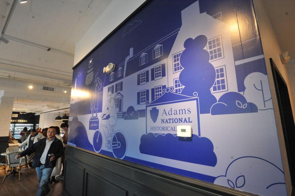 A mural depicting the Adams National Historic Park graces a wall at the new Paris Baguette on Hancock Street in North Quincy, Sunday, Dec. 10, 2023.