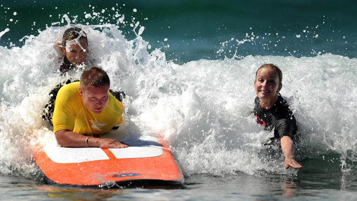 Bo Derek surving in a black suit with a man