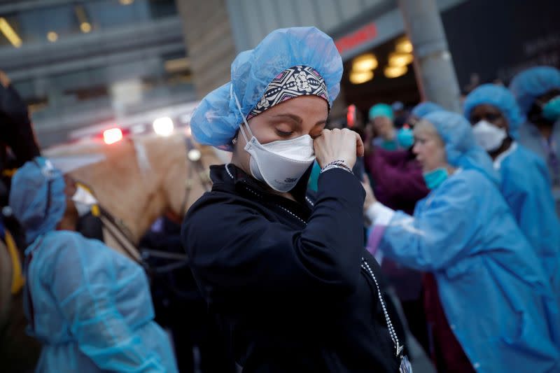 FILE PHOTO: Nurse wipes away tears as NYPD police thank healthcare workers at NYU Langone Medical Center during outbreak of coronavirus disease (COVID-19) in New York