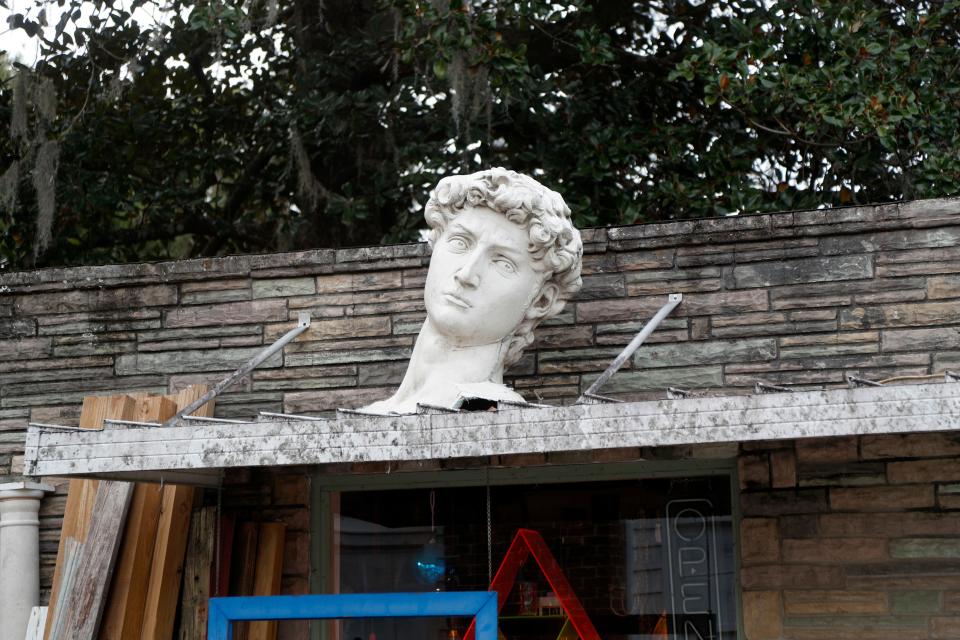 A large bust sits on the awning of an antique shop in Springfield.