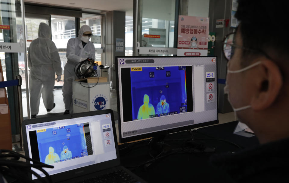 A thermal camera monitors shows the body temperature of people at the gate of an indoor gymnasium in Seoul, South Korea, Tuesday, Feb. 25, 2020. China and South Korea on Tuesday reported more cases of a new viral illness that has been concentrated in North Asia but is causing global worry as clusters grow in the Middle East and Europe. (AP Photo/Lee Jin-man)