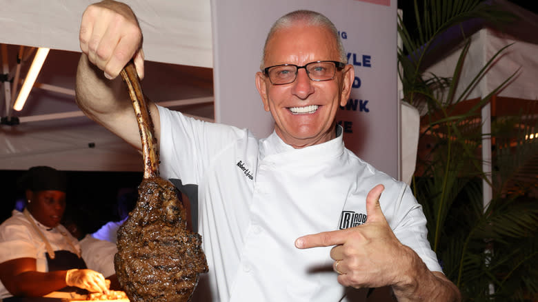 Robert Irvine holding a massive chunk of meat